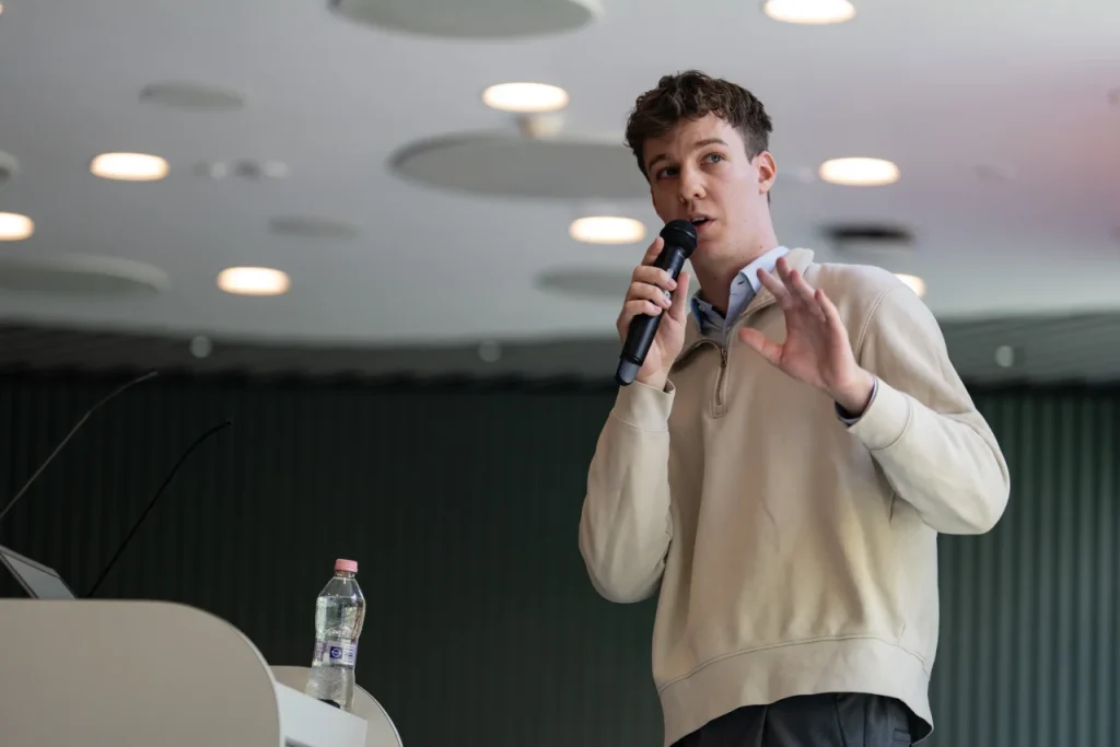 Fiatal férfi mikrofonnal előadást tart