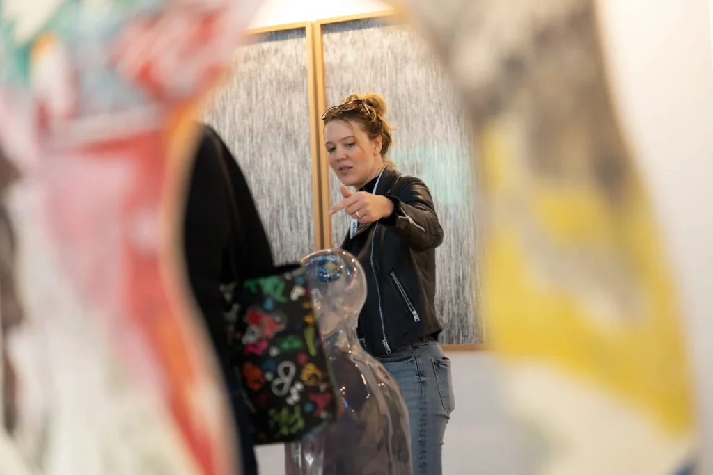 Nő a kiállításon mutatva beszél