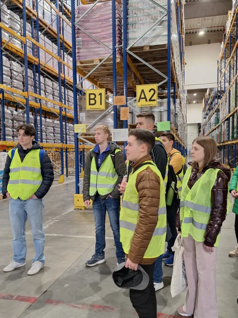 Diákok raktárbejáráson láthatósági mellényben