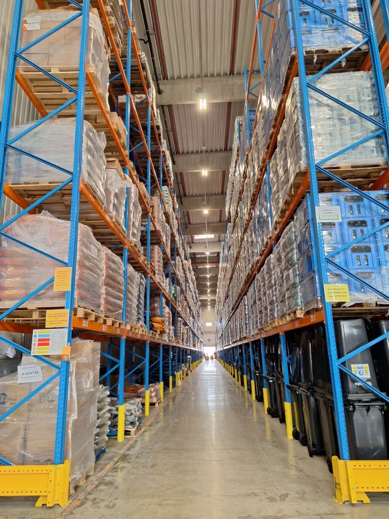 Raktári folyosó magas polcok között