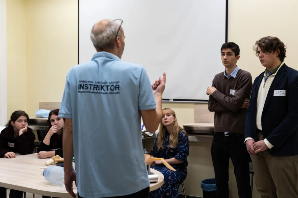 Instruktor a diákok előtt elsősegély bemutatón, eszközök az asztalon