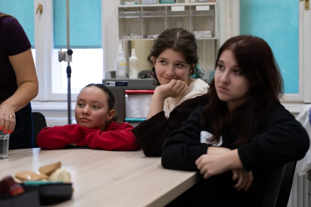 Diákok figyelnek tantermi előadáson asztalnál